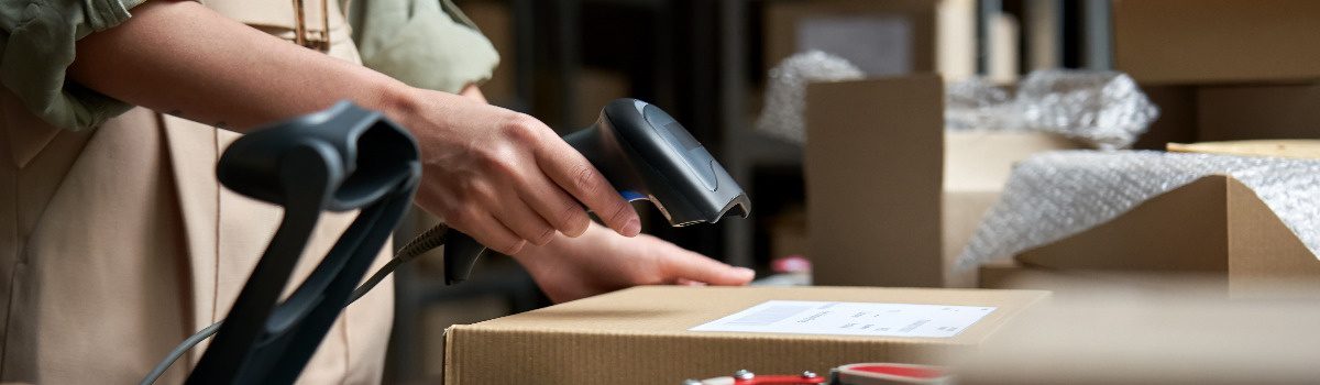 female-seller-scanning-ecommerce-shipping-box-in-d-M4UA8SB(1)(1)